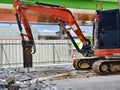 Excavator using hydraulic hammer for breaking concrete at a construction site Royalty Free Stock Photo