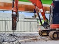 Excavator using hydraulic hammer for breaking concrete at a construction site Royalty Free Stock Photo
