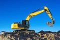 Excavator work on the ground on background blue sky. Royalty Free Stock Photo