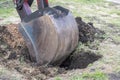 Excavator work. The iron ladle digs into the ground. Digging a hole.