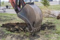 Excavator work. The iron ladle digs into the ground. Digging a hole.