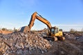 Excavator work at landfill with concrete demolition waste. Salvaging and recycling building and construction materials. Royalty Free Stock Photo