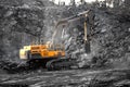 Excavator work loading of coal into Yellow mining truck. Open pit mine industry