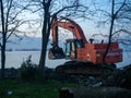 Excavator work at night. Overtime work. The work of construction equipment on the seashore. Batumi. Fortified shores. at sunset