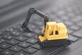 Excavator working on black laptop keybaord Royalty Free Stock Photo