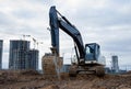 Excavator working at construction site. Backhoe digs ground for the foundation and for paving out sewer line. Construction