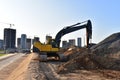 Excavator working at construction site. Backhoe on road work and earthworks. Earth-Moving Heavy Equipment for construction jobs, Royalty Free Stock Photo