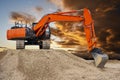 Excavator working on construction site with dramatic clouds on sky Royalty Free Stock Photo