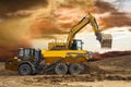 Excavator working on construction site with dramatic clouds on sky Royalty Free Stock Photo