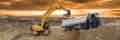Excavator working on construction site with dramatic clouds on sky Royalty Free Stock Photo