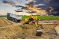 Excavator working on construction site with dramatic clouds on sky Royalty Free Stock Photo