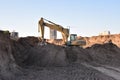 Excavator working at construction site on earthworks. Backhoe digging building foundatio. Construction machinery for excavating,