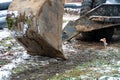 The excavator is working on the construction site to replace the pipeline in winter. Digging holes for laying new pipes for