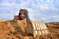 Excavator working on earthmoving at open pit mining. Backhoe digs gravel in quarry. Construction machinery for excavation, loading Royalty Free Stock Photo