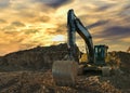 Excavator working on earthmoving at open pit mining on sunset background. Backhoe digs sand and gravel in quarry. Heavy Royalty Free Stock Photo