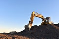 Excavator working on earthmoving at open pit mining. Yellow Backhoe digs sand and gravel in quarry. Heavy Construction Equipment Royalty Free Stock Photo