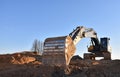 Excavator working on earthmoving at open pit mining. Yellow Backhoe digs sand and gravel in quarry. Heavy Construction Equipment