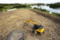 Excavator working on a ground by a rive. Selective focus, aerial view. Starting new big project in construction industry. Heavy