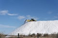 Excavator working on top of a huge pile of salt in the salt flats.