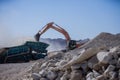 Excavator working in quarry with other machines