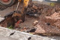 Excavator working on the Repair of pipe water and sewerage on road Royalty Free Stock Photo