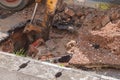 Excavator working on the Repair of pipe water and sewerage on road Royalty Free Stock Photo