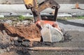 Excavator working on the Repair of pipe water and sewerage on road Royalty Free Stock Photo