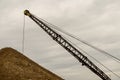 Excavator working in the river gravel quarry against the background of the forest. Extraction of natural resources