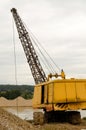 Excavator working in the river gravel quarry against the background of the forest. Extraction of natural resources