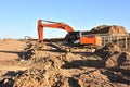 Excavator Working On Road Construction in City. Backhoe on Earthworks. Heavy Construction Equipment Machines in Action. Big Red