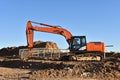 Excavator Working On Road Construction in City. Backhoe on Earthworks. Heavy Construction Equipment Machines in Action. Big Red