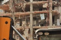 Excavators on a demolition site with old demolished building in the background. Old building being demolished to make room for new Royalty Free Stock Photo