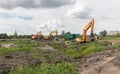 Excavators dig the earth with a bucket. Clearing the construction site. Drainage of swamps. Peat mining.