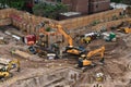 Excavators digging on skyscraper construction site with foundation pit Royalty Free Stock Photo