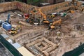 Excavators digging on skyscraper construction site with foundation pit. Royalty Free Stock Photo