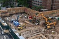 Excavators digging on skyscraper construction site with foundation pit. Royalty Free Stock Photo