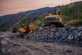 Excavators and dump trucks working on earthmoving at open pit mine in mining and processing plant Royalty Free Stock Photo