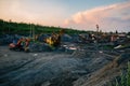 Excavators and dump trucks working on earthmoving at open pit mine in mining and processing plant Royalty Free Stock Photo