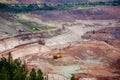 Excavators and dump trucks working on earthmoving at open pit mine in mining and processing plant Royalty Free Stock Photo