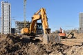 Excavators during earthmoving at construction site. Backhoe dig ground for the construction of foundation and laying sewer pipes Royalty Free Stock Photo