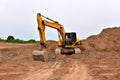 Excavators during earthworks at construction site. Backhoe the digging pit for construct building foundation. Paving out sewer