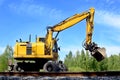 Rail excavator working with rubble. Royalty Free Stock Photo