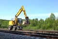 Rail excavator working with rubble. Royalty Free Stock Photo