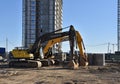 Excavators VOLVO and JCB on earthworks at construction site. Backhoe on foundation work and road construction. Tower cranes in Royalty Free Stock Photo