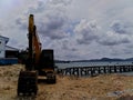 Excavators work to dig the soil in a beautiful seaside view.