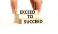 Exceed to succeed symbol. Concept words Exceed to succeed on beautiful wooden blocks. Beautiful white table white background.