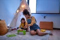 Excellent babysitter you can count on. African american woman baby sitter entertaining caucasian cute little girl. Kid Royalty Free Stock Photo