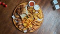 An excellent beer snack is a set of chicken nuggets fries with parchment sauce on a stone tray. Pub food. Close up Royalty Free Stock Photo