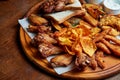 An excellent beer snack is a set of chicken nuggets fries with parchment sauce on a stone tray. Pub food. Close up Royalty Free Stock Photo