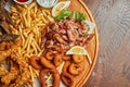 An excellent beer snack is a set of chicken nuggets fries with parchment sauce on a stone tray. Pub food. Close up Royalty Free Stock Photo